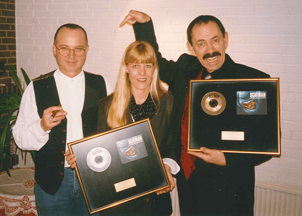 Manfred and Mette Zahringer, holding gold awards, with John